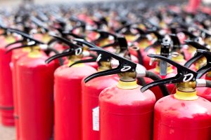 What are the requirements for fire extinguishers in different types of buildings according to the Alberta Fire Code?